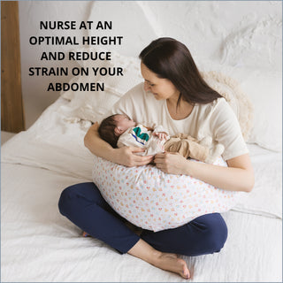 Woman using a white maternity pillow for nursing in a modern bedroom setting